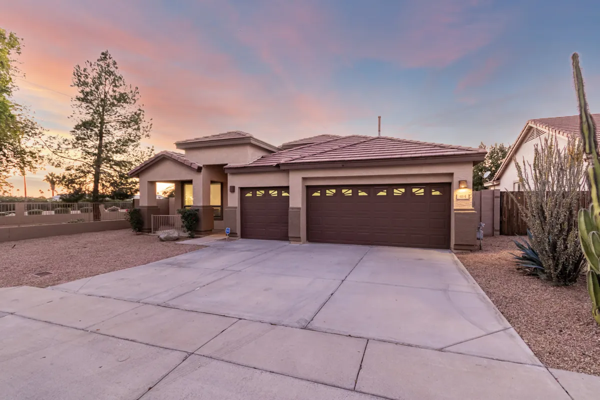 The home's front entrance is highlighted by beautifully landscaped areas with cacti and a welcoming pathway, evoking the warm desert environment of Mesa. The scene conveys a sense of arrival and the anticipation of relaxing evenings after a day spent out in the local area.