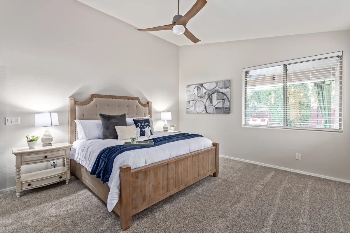 A tranquil bedroom with a comfortable bed, nightstands, a large window, and calming artwork. The scene exudes a sense of peace and privacy, ideal for guests or family members seeking their own restful haven within the home.