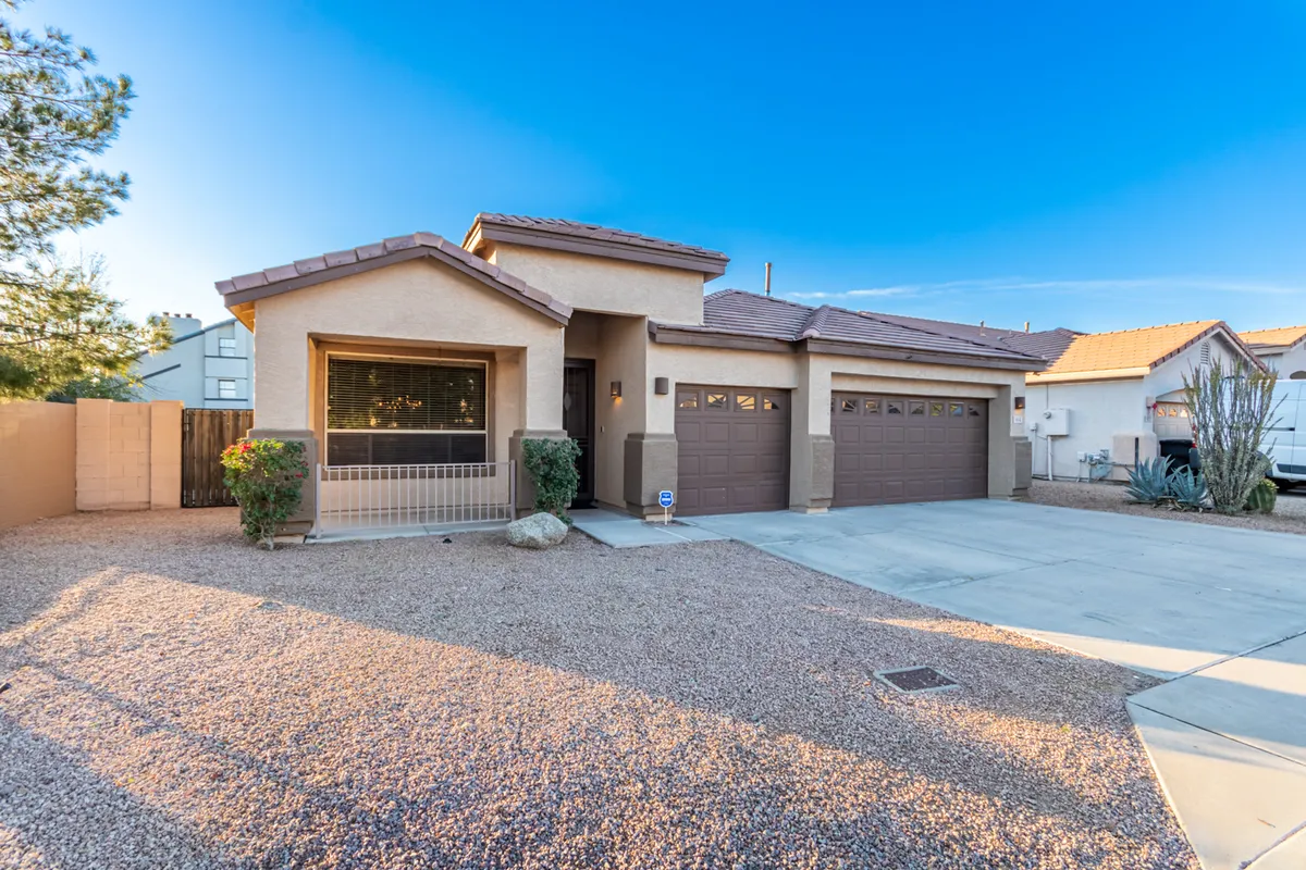This exterior shot features the home's welcoming front entrance, garage doors, and attractive landscaping. The setup highlights the convenience of garage parking for long-term guests and suggests everyday ease for those staying a while.